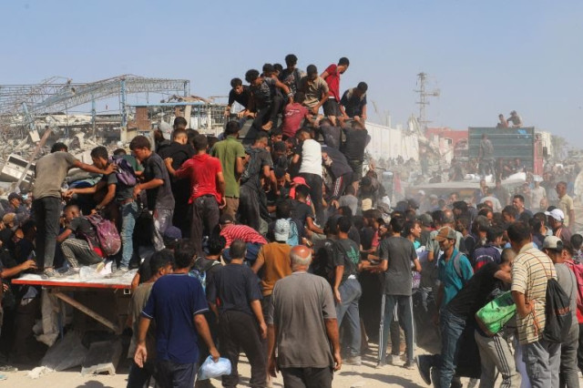 Palestinians ride on the back of a truck, after aid supplies that entered Gaza through Israel were distributed, in Beit Lahiya in the northern Gaza Strip, on Sunday