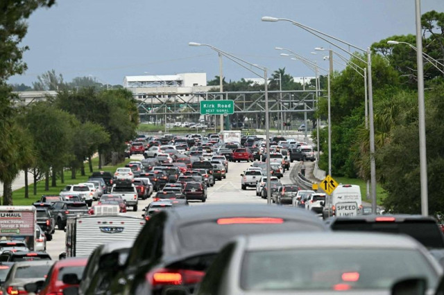 Cars are stuck in traffic after police blocked the road in West Palm Beach, Florida, on September 15, 2024 following a shooting incident at former US president Donald Trump's golf course.