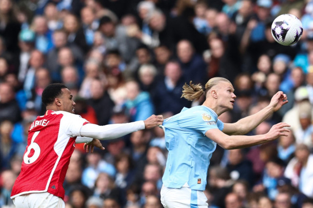 Arsenal's Brazilian defender #06 Gabriel Magalhaes pulls the jersey of Manchester City's Norwegian striker #09 Erling Haaland (R) as they fight for the ball during the English Premier League football match between Manchester City and Arsenal at the Etihad