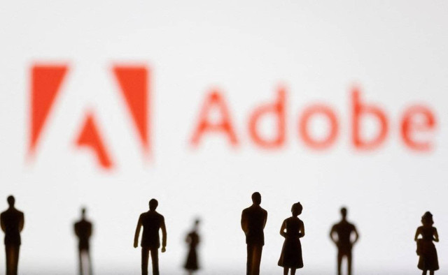 Figurines are seen in front of the Adobe logo in this illustration taken June 13, 2022