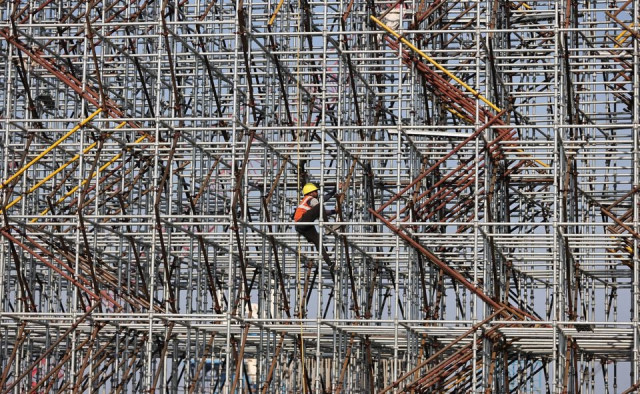 A worker climbs a scaffolding at a construction site in Mumbai, India, January 19, 2022.