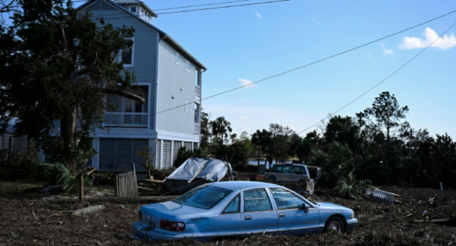 Debris surrounds a damaged car after Hurricane Helene made landfall in Steinhatchee, Florida, on September 27, 2024.