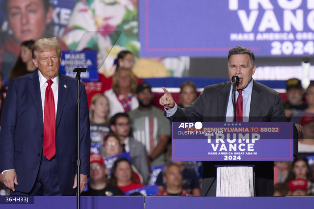 (L-R) Former US President and Republican presidential candidate Donald Trump looks on as US Senate candidate from Pennsylvania David McCormick speaks during a campaign event at the Bayfront Convention Center in Erie, Pennsylvania, September 29, 2024