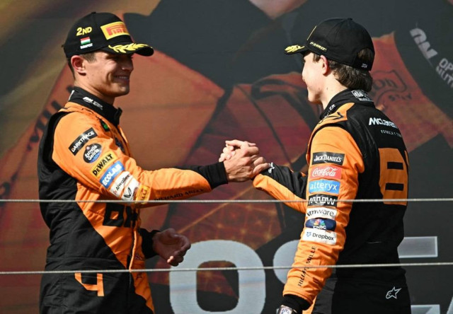 McLaren's Australian driver Oscar Piastri (R) is congratulated by McLaren's British driver Lando Norris on the podium after the Formula One Hungarian Grand Prix at the Hungaroring race track in Mogyorod near Budapest on July 21, 2024.