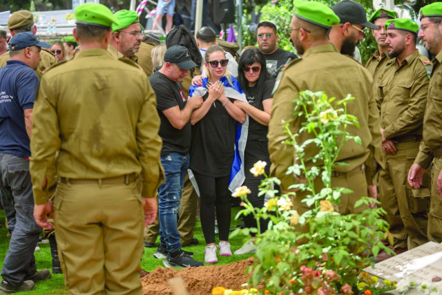 Picture of Family and the wife of Israeli reservist Master Sgt. Valeri Chefonov gather around his grave during his funeral at the military cemetery in Netanya, Israel, on Friday, July 12, 2024. Chefonov, 33, was killed, in northern Israel on Thursday in a