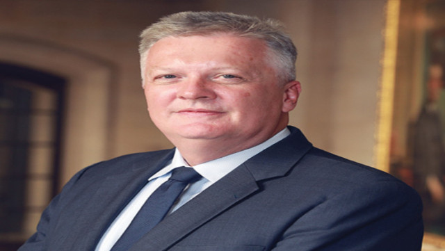 Huw Pill, Chief Economist at the Bank of England, in a formal setting wearing a suit and tie.