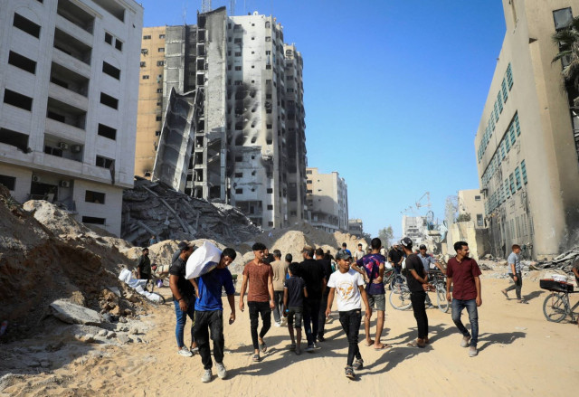 Palestinians gather as they inspect the damages after Israeli forces withdrew from a part of Gaza City, following a ground operation, amid the Israel-Hamas conflict, in Gaza City, July 12, 2024