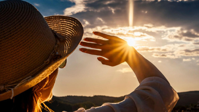 Photo of a woman shading herself from the sun