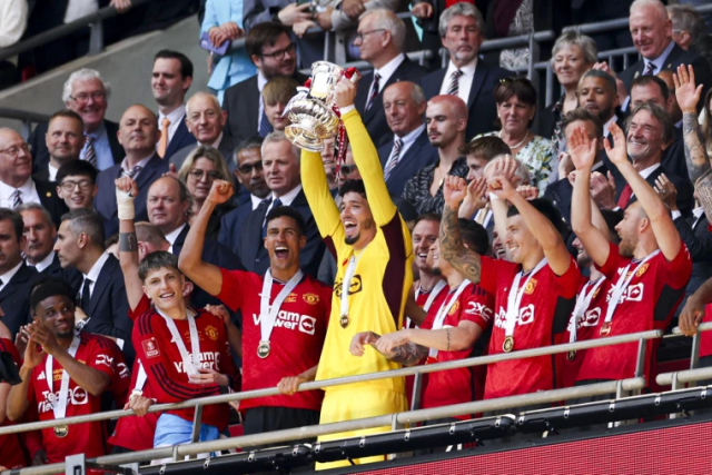 Manchester United's players celebrate with the trophy after winning the English FA Cup final soccer match between Manchester City and Manchester United at Wembley Stadium in London on Saturday