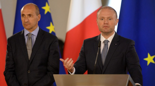 Malta’s Prime Minister Joseph Muscat (R) gives a press conference flanked by then Minister for Health Chris Fearne