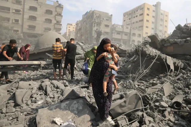 Palestinians evacuate following an Israeli airstrike on the Sousi Mosque in Gaza on Oct. 9
