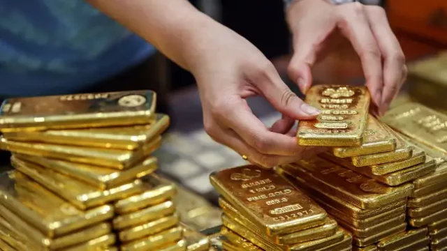 picture of employee arranges gold bars