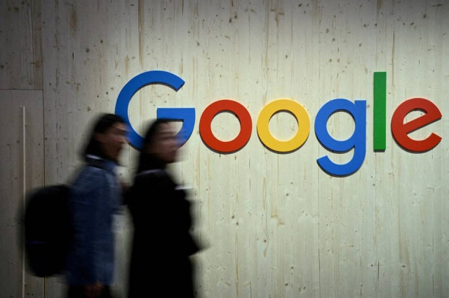 People walk next to a Google logo during a trade fair in Hannover Messe, in Hanover, Germany, April 22, 2024.