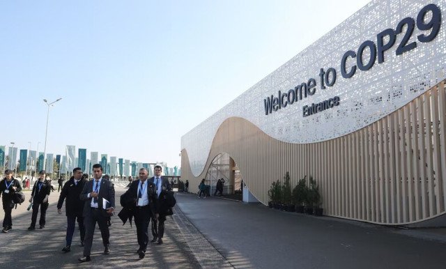 COP29 venue in Baku with delegates walking outside, emphasizing climate summit discussions on finance and global warming.