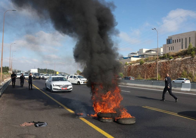 Israeli police work to extinguish a fire lit by anti-government protectors on a day of protests marking 9 months since the deadly October 7 attack, under the slogan "Israel comes to a standstill", near Shoresh, Israel, July 7, 2024