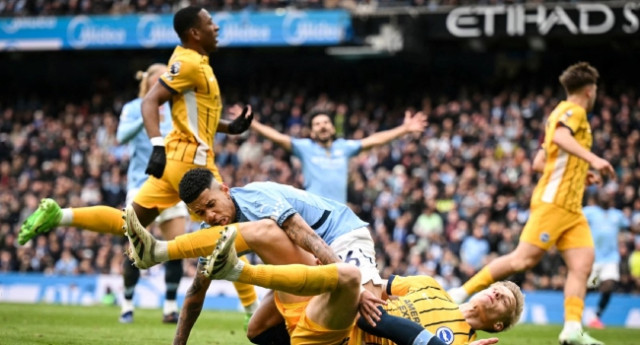 Manchester City’s Brazilian midfielder Savinho (up) collides with Brighton’s Dutch defender  Jan Paul van Hecke as he shoots the ball and misses to score during the English Premier League football match between Manchester City and Brighton and Hove Albion