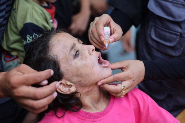 A medic administers a polio vaccine to a Palestinian girl at the al-Daraj neighborhood clinic in Gaza City on September 10, 2024.