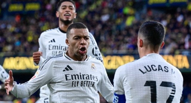 Real Madrid’s French forward  Kylian Mbappe celebrates with teammates Real Madrid’s Spanish defender  Lucas Vazquez (R) and Real Madrid’s English midfielder Jude Bellingham (L) after scoring their second goal during the Spanish League football match betwe